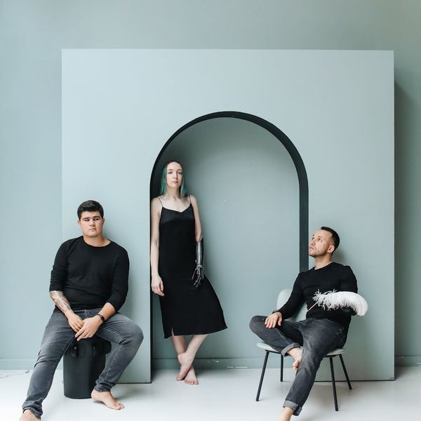 A diverse group of people smiling and moving freely in a bright studio space.