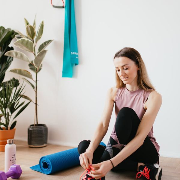 Yoga mat, water bottle, and comfortable sportswear laid out neatly on a floor.